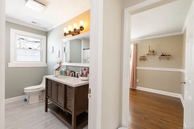 a bathroom with a sink a toilet and a mirror
