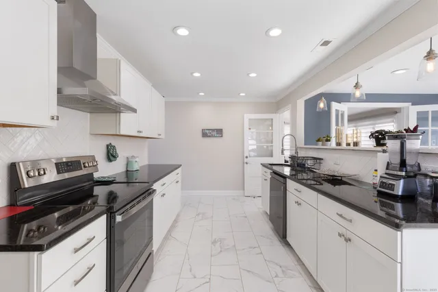 a kitchen with granite countertop a sink stove and cabinets