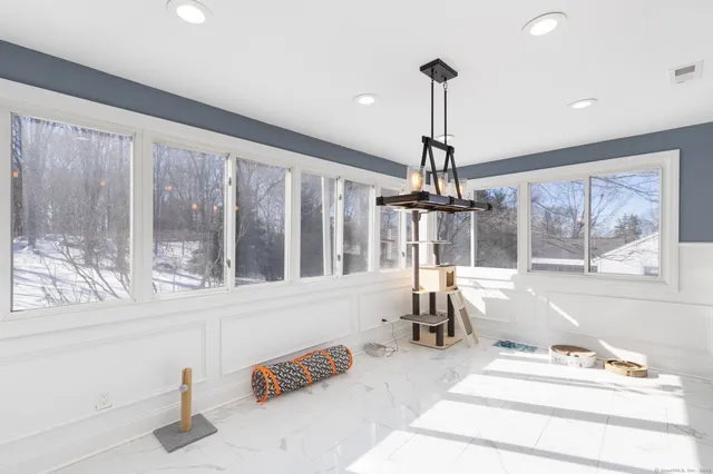 a dining room with wooden floor and a chandelier