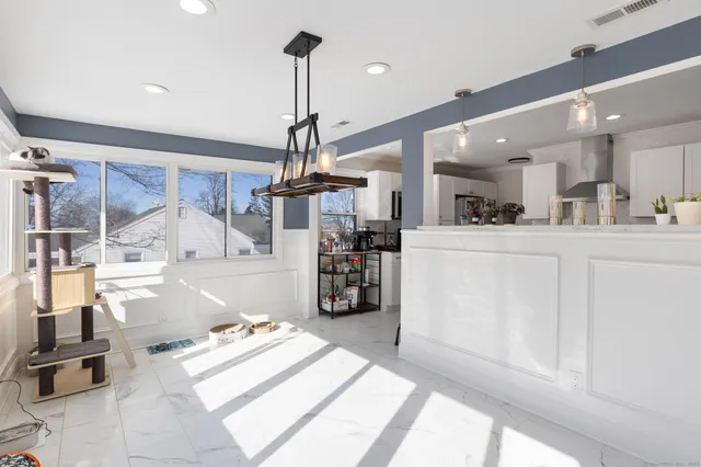 a kitchen with stainless steel appliances kitchen island granite countertop a refrigerator a stove and white cabinets