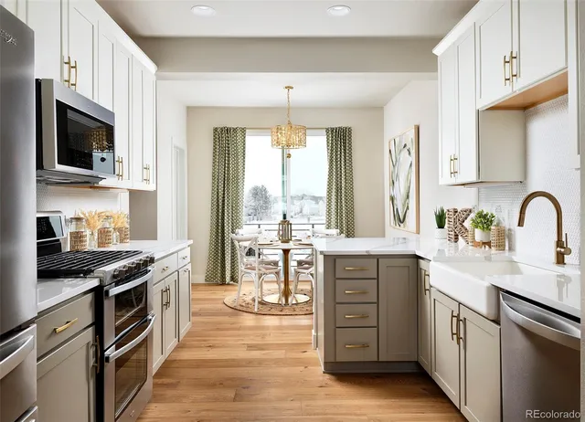 a kitchen with stainless steel appliances granite countertop a stove top oven a sink dishwasher a dining table and chairs with wooden floor