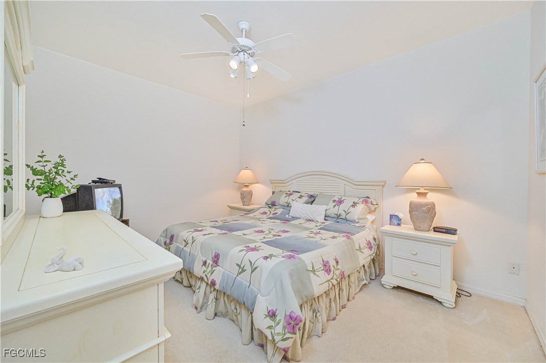 14121 Brant Point Circle, Unit 1202 Fort Myers, FL 33919 - Photo 16 of 47 a bedroom with a bed and a chandelier