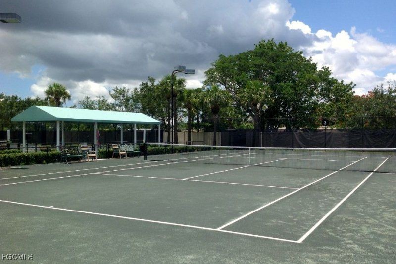 14121 Brant Point Circle, Unit 1202 Fort Myers, FL 33919 - Photo 35 of 47 a view of a tennis ground with large trees