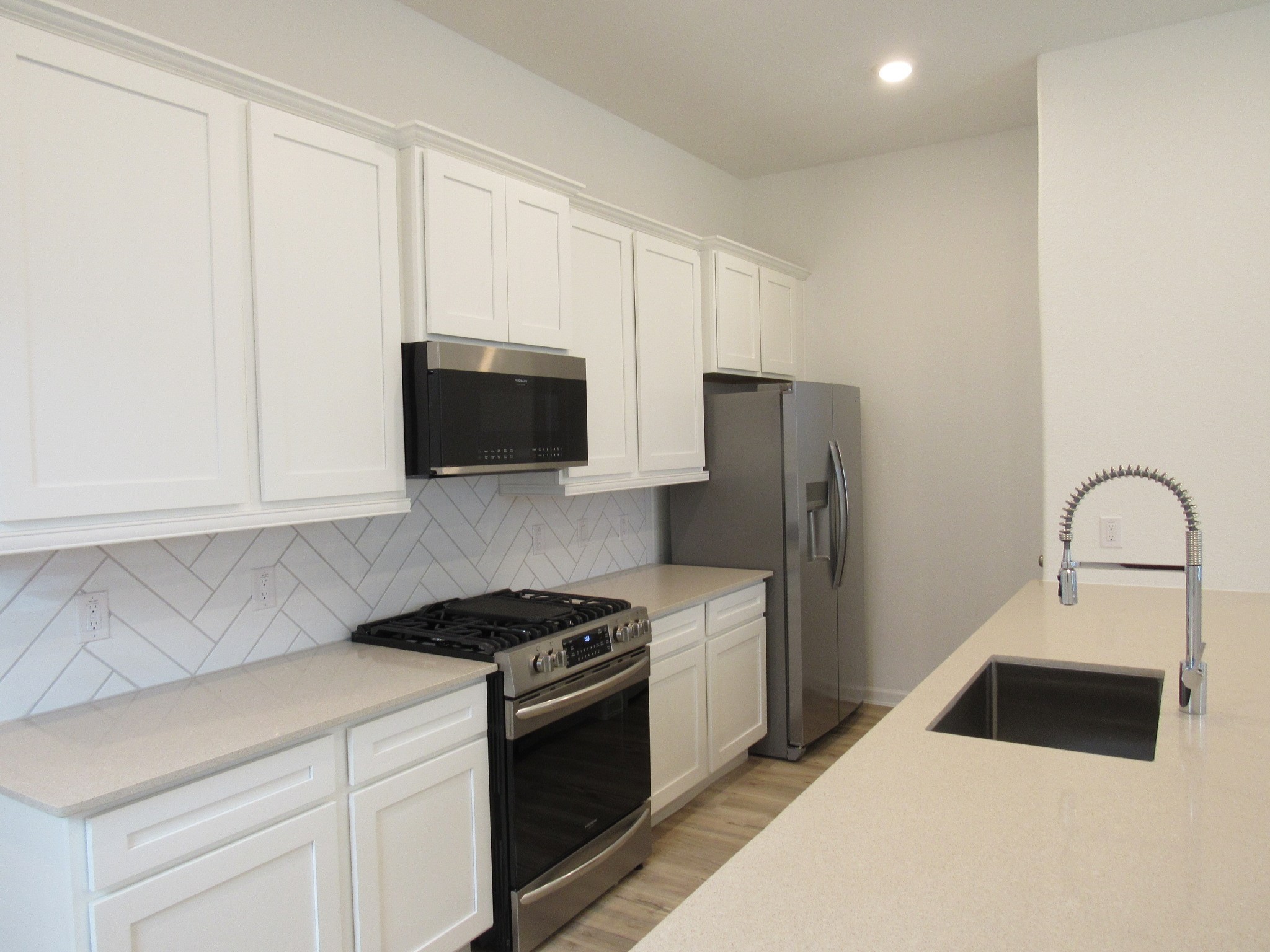 542 Dry Fork Lane Conroe, TX 77304 - Photo 4 of 9 a kitchen with stainless steel appliances a stove microwave and sink