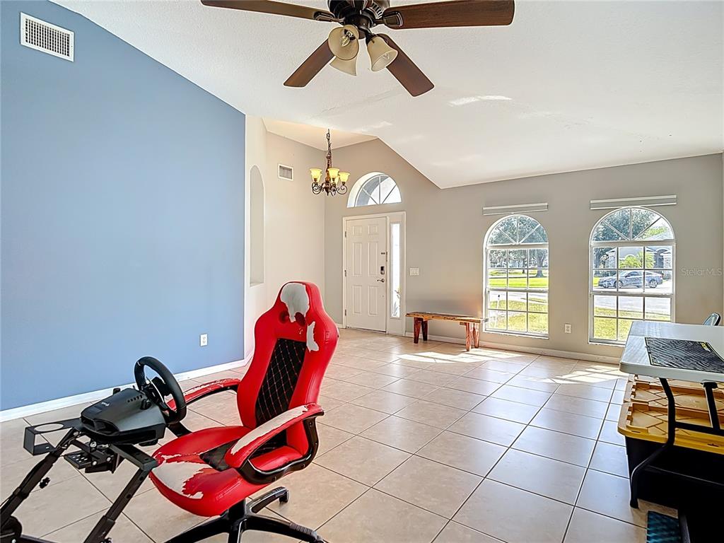 12153 South Bridge Terrace Hudson, FL 34669 - Photo 13 of 60 a living room with furniture a dining table and a chandelier