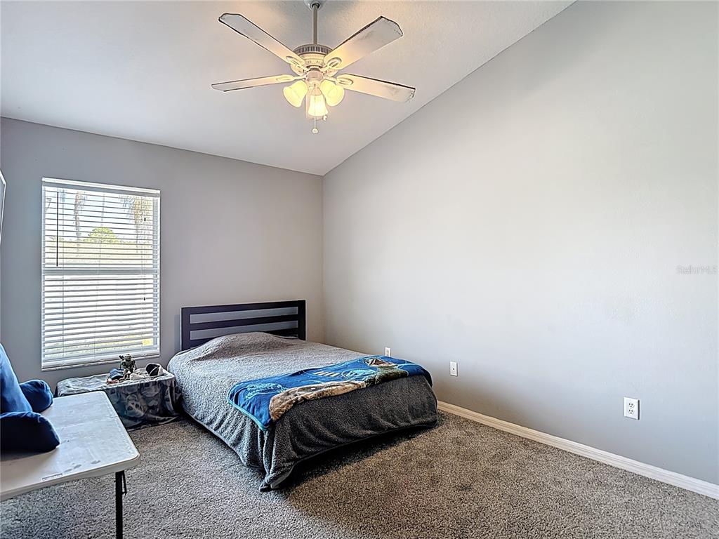 12153 South Bridge Terrace Hudson, FL 34669 - Photo 24 of 60 a bedroom with a bed and a chandelier