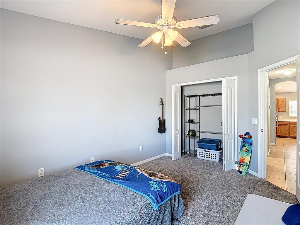 12153 South Bridge Terrace Hudson, FL 34669 - Photo 25 of 60 a bedroom with a bed and a chandelier