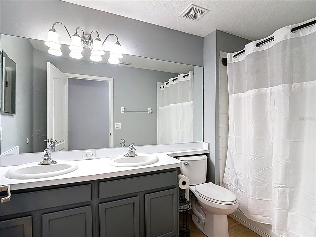 12153 South Bridge Terrace Hudson, FL 34669 - Photo 27 of 60 a bathroom with a double vanity sink mirror and toilet