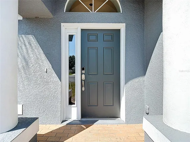 a living room with furniture kitchen view and a wooden floor