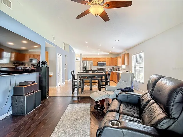 a living room with furniture ceiling fan and a wooden floor
