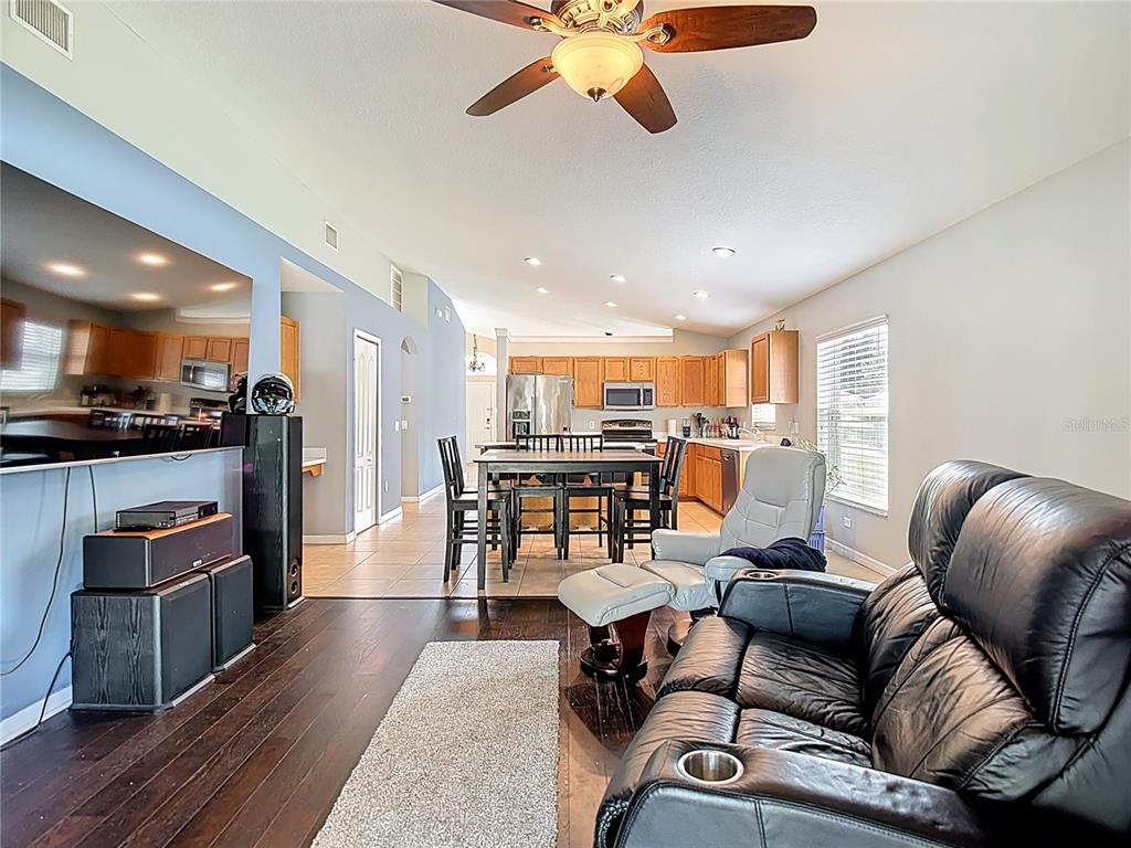 12153 South Bridge Terrace Hudson, FL 34669 - Photo 4 of 60 a living room with furniture kitchen view and a wooden floor