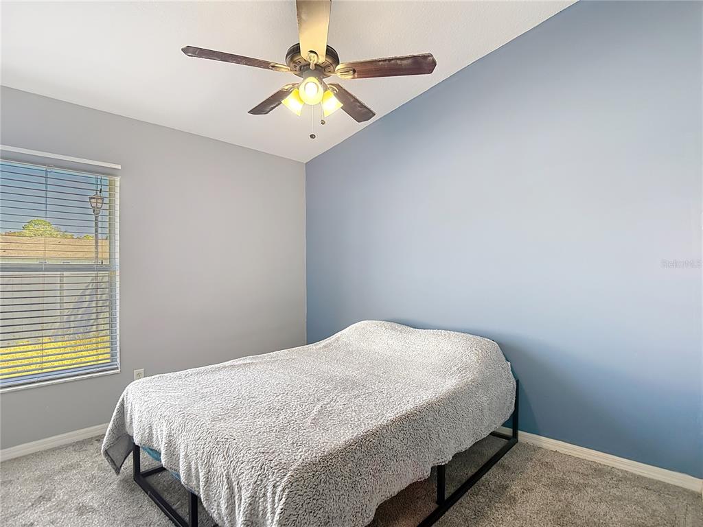 12153 South Bridge Terrace Hudson, FL 34669 - Photo 42 of 60 a bedroom with a bed and a chandelier