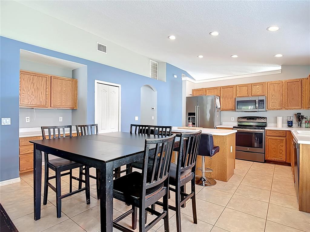 12153 South Bridge Terrace Hudson, FL 34669 - Photo 50 of 60 a kitchen with stainless steel appliances kitchen island granite countertop a dining table chairs and granite counter tops
