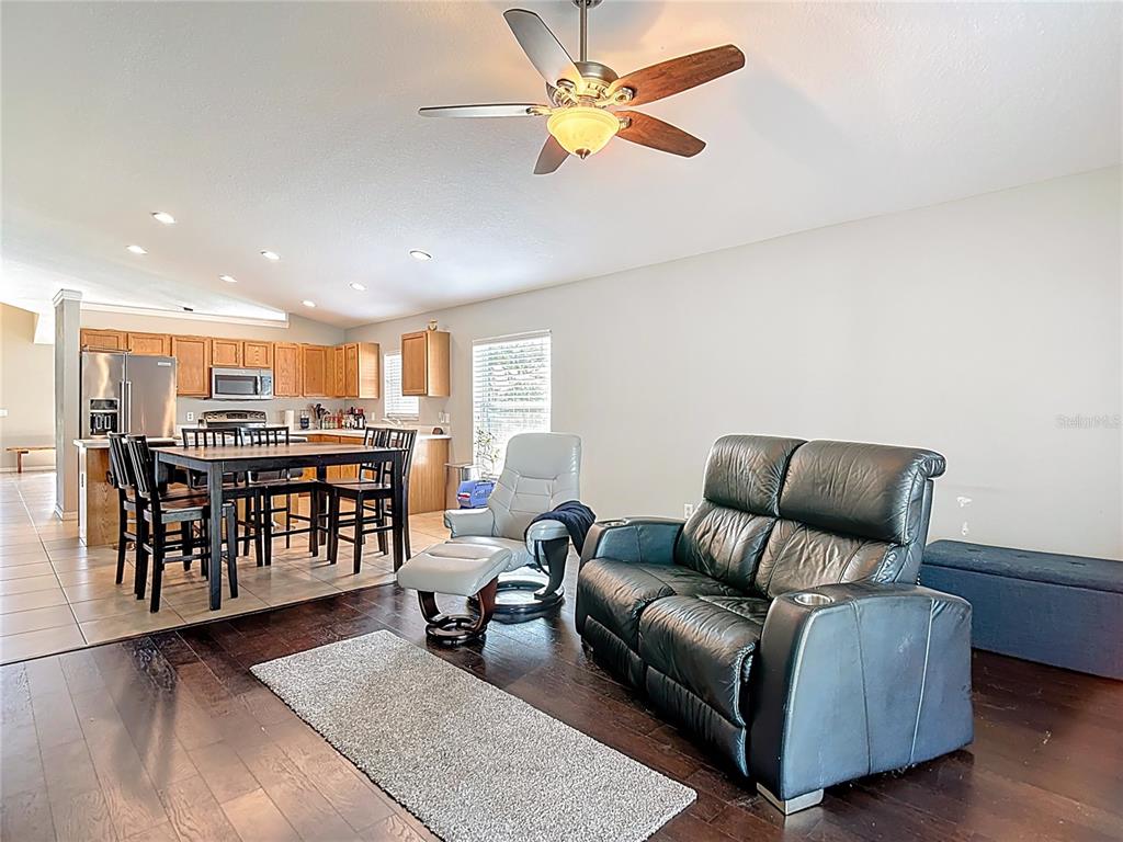 12153 South Bridge Terrace Hudson, FL 34669 - Photo 5 of 60 a living room with furniture ceiling fan and a wooden floor
