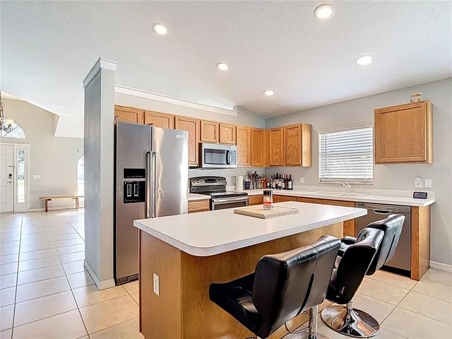 a kitchen with stainless steel appliances kitchen island granite countertop a sink and cabinets
