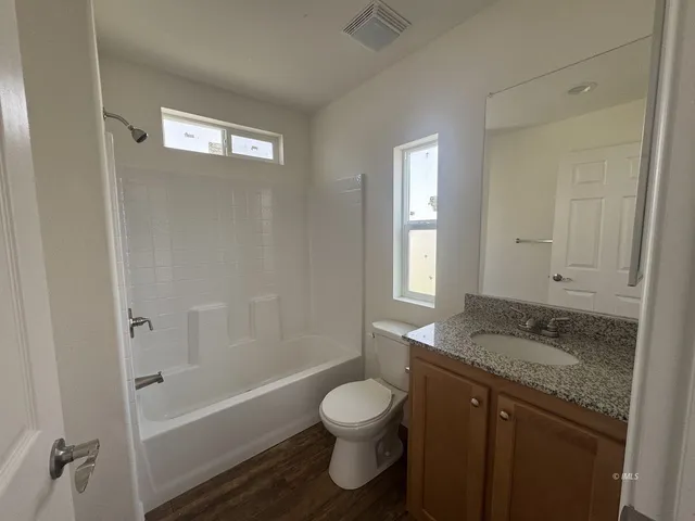 a bathroom with a granite countertop sink toilet a bathtub and a shower