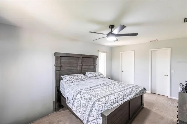 a bedroom with a bed and a ceiling fan