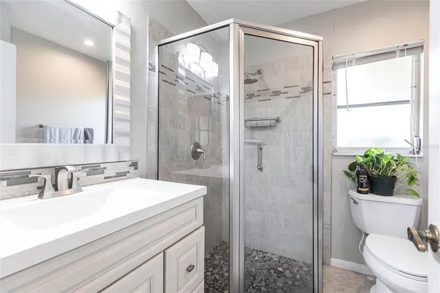 a bathroom with a sink a toilet and shower