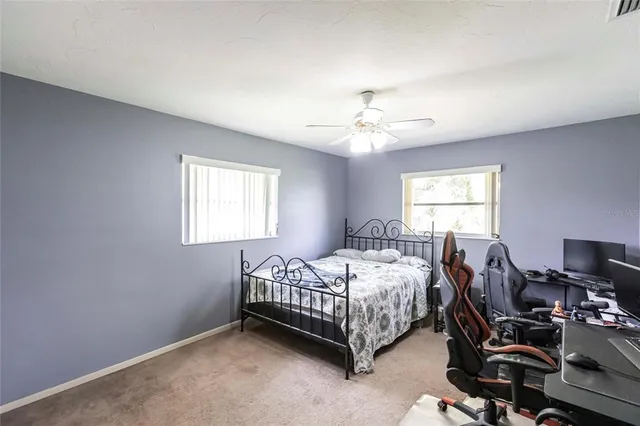 a bedroom with a bed a chair and a chandelier