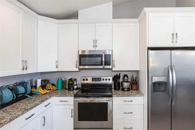 a kitchen with stainless steel appliances granite countertop a refrigerator sink and cabinets