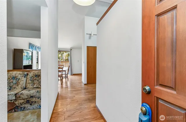 a view of hallway with furniture and wooden floor