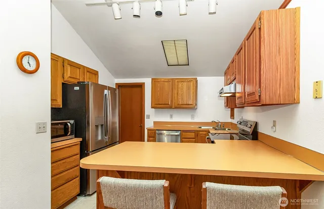 a room with a table chairs and a refrigerator