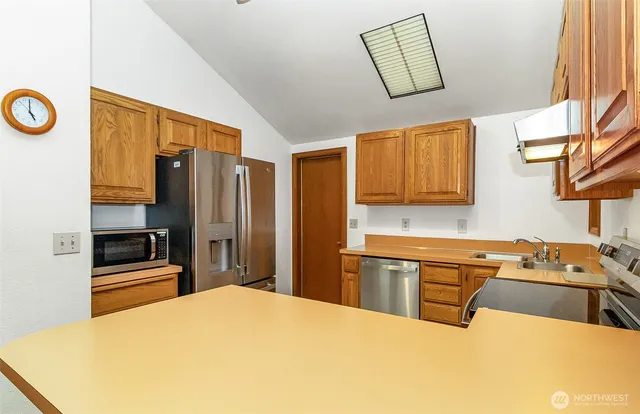 a kitchen with stainless steel appliances a stove a sink and a refrigerator