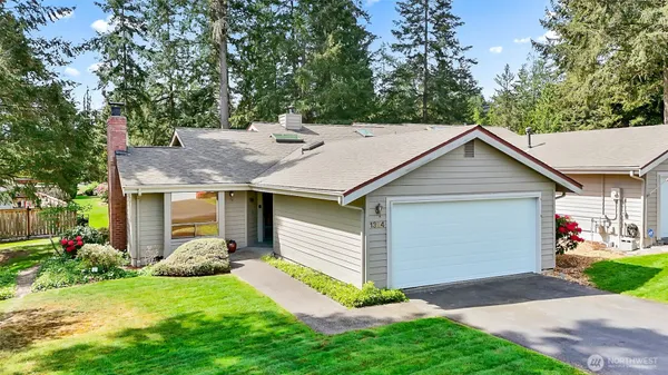 a front view of house with yard and trees in the background