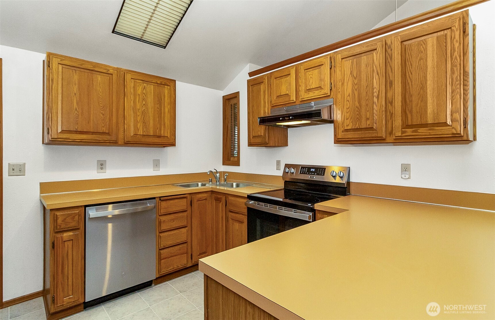 1324 Boise Street Fircrest, WA 98466 - Photo 21 of 39 a kitchen with stainless steel appliances granite countertop a stove a sink dishwasher and a microwave oven with wooden cabinets
