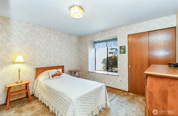 a bedroom with a bed and a lamp on table