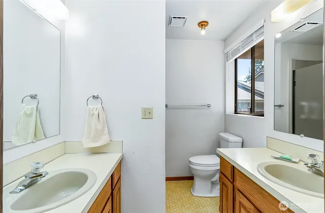 a bathroom with a granite countertop sink toilet a mirror and shower