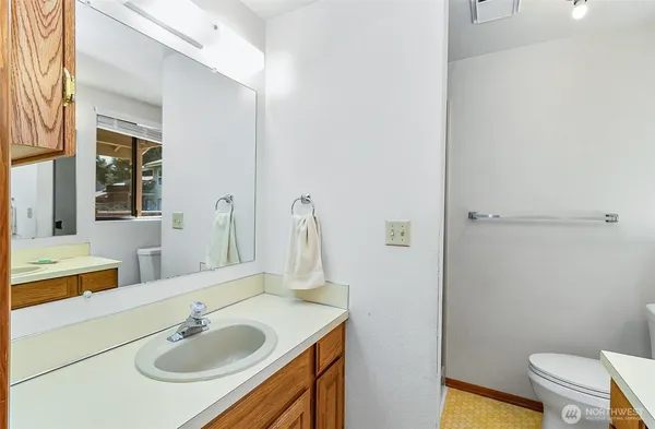 a bathroom with a sink and a mirror with toilet