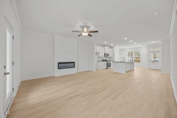 a view of empty room with wooden floor and ceiling fan