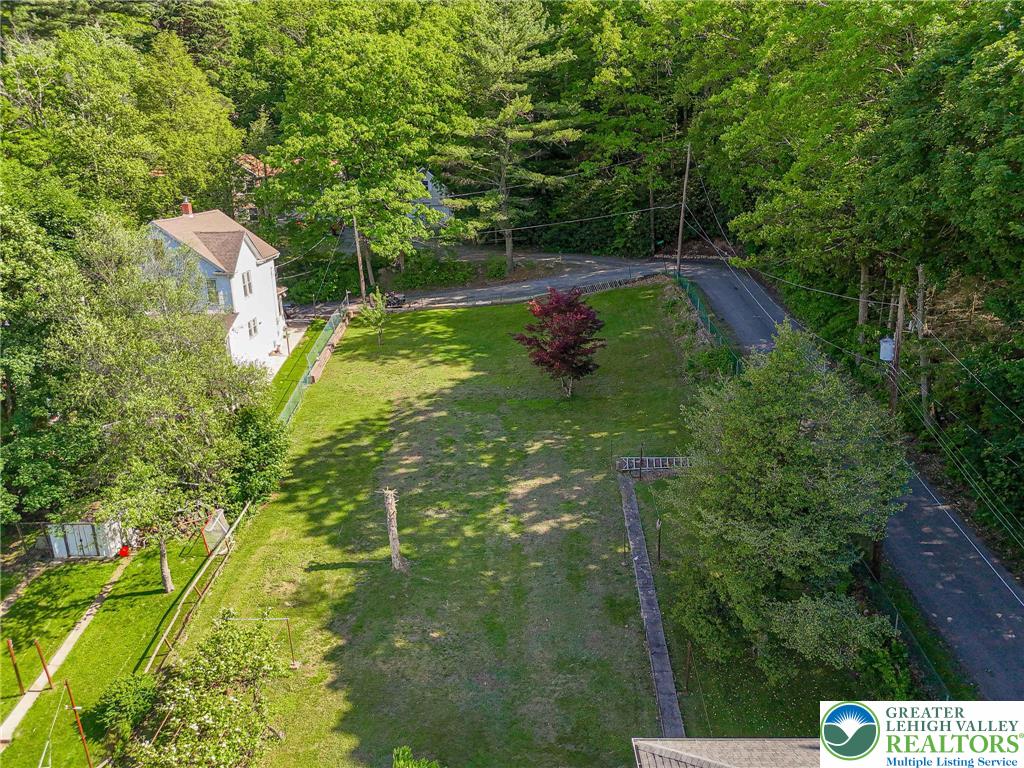 159 West Ridge Street Nesquehoning, PA 18240 - Photo 45 of 55 A spacious, verdant lot with a classic white home, offering ample outdoor potential.