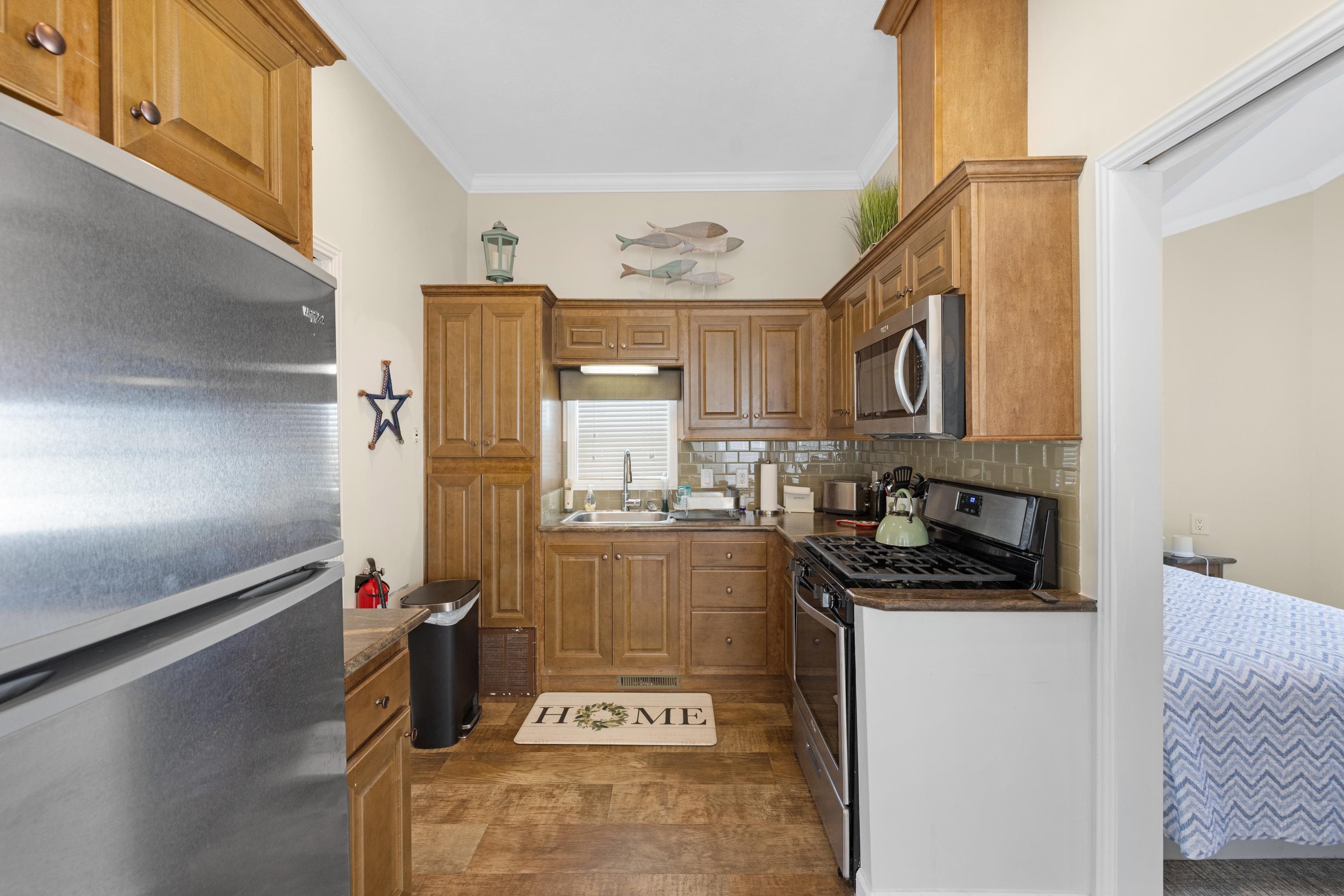 4100 Highway 9 Rio Grande, NJ 08242 - Photo 9 of 28 a kitchen with stainless steel appliances granite countertop a refrigerator a stove and a sink with wooden floor