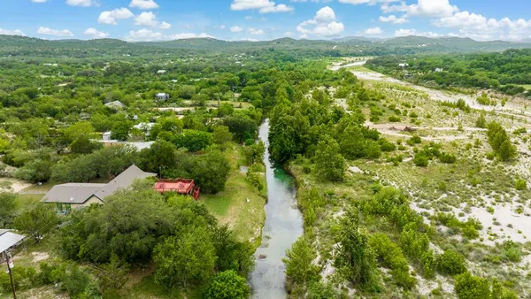 a view of a green yard with large trees