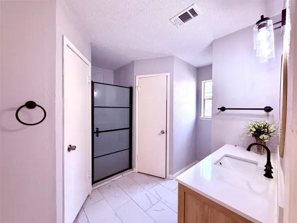 a bathroom with a granite countertop sink a mirror and a shower