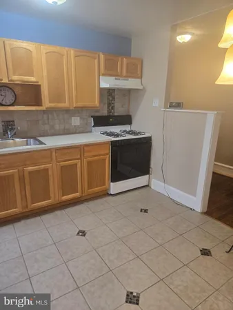 a kitchen with granite countertop a stove a sink and a microwave