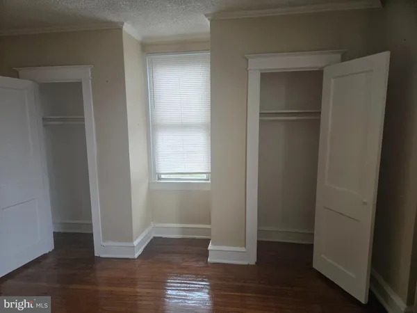 an empty room with wooden floor and closet