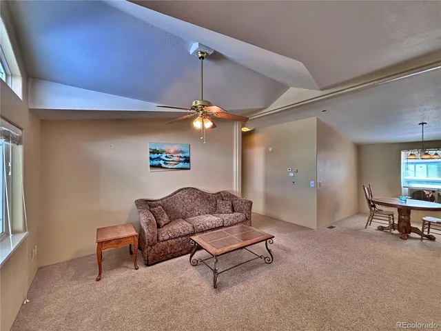 a living room with furniture and a ceiling fan