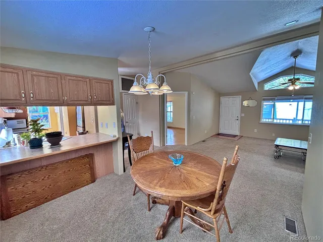 a view of a dining room with furniture and a chandelier