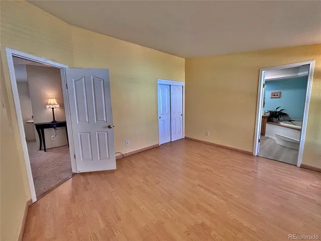a view of a livingroom with wooden floor and a bathroom