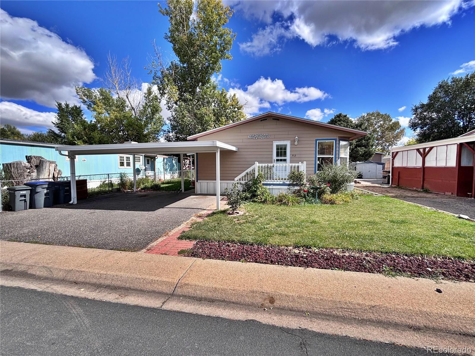 712 Meadowlark Drive Lafayette, CO 80026 - Photo 2 of 40 a front view of a house with a yard and potted plants