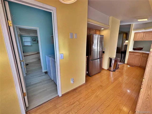 a view of a hallway with wooden floor and a living room