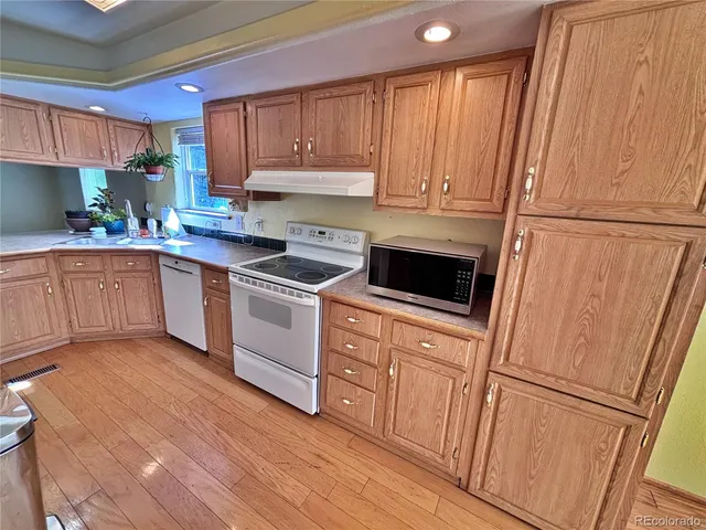a kitchen with white cabinets and white appliances