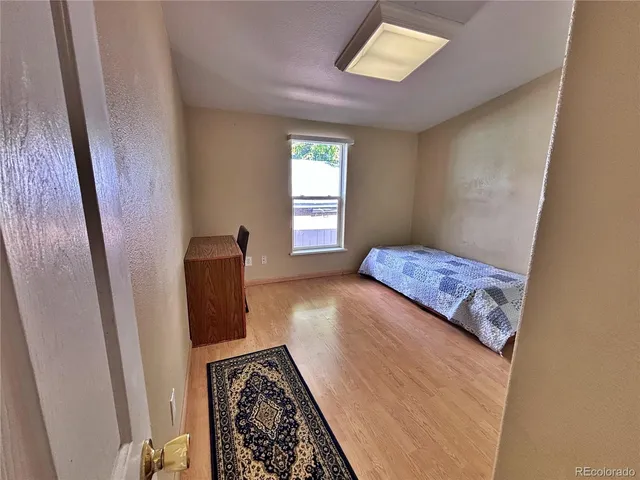 a spacious bedroom with a bed and a dresser