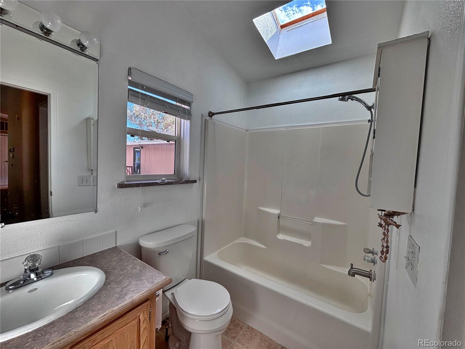 712 Meadowlark Drive Lafayette, CO 80026 - Photo 39 of 40 a bathroom with a granite countertop sink toilet and shower