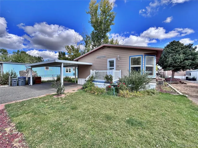 a front view of a house with a yard and potted plants