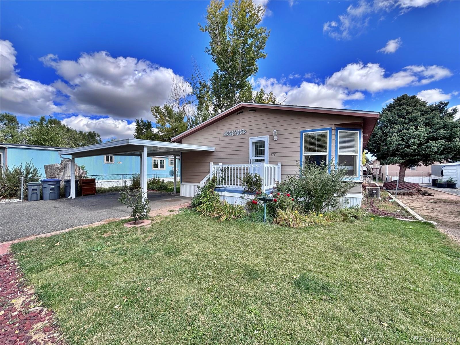 712 Meadowlark Drive Lafayette, CO 80026 - Photo 4 of 40 a front view of a house with a yard and potted plants
