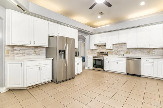 a kitchen with white cabinets stainless steel appliances and sink
